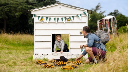Boy is hiding in a giant pop-up bumblebee hive in the Garden of Imagination